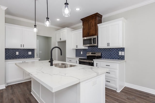 kitchen featuring appliances with stainless steel finishes, dark wood-type flooring, ornamental molding, a sink, and an island with sink