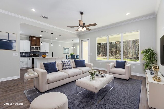 living room featuring baseboards, visible vents, dark wood-style flooring, and crown molding