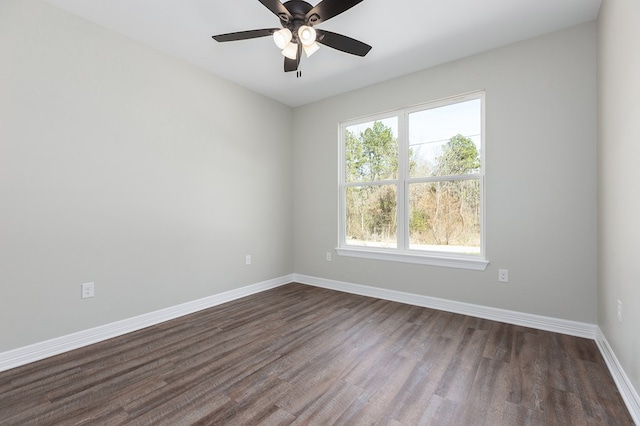 spare room featuring dark wood-type flooring, ceiling fan, and baseboards