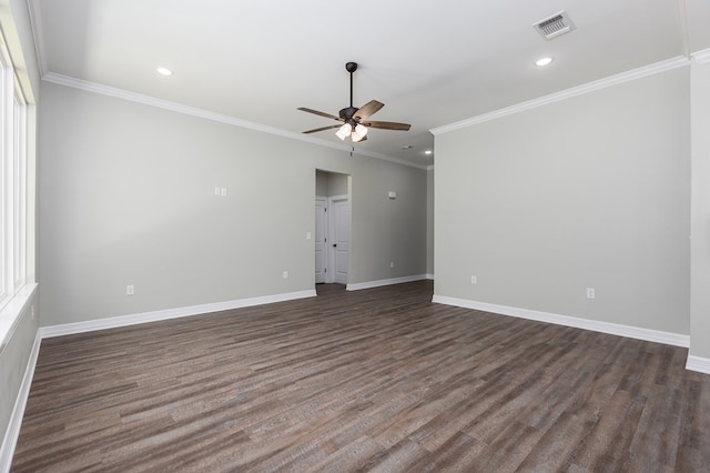 unfurnished room with crown molding, visible vents, dark wood-type flooring, a ceiling fan, and baseboards