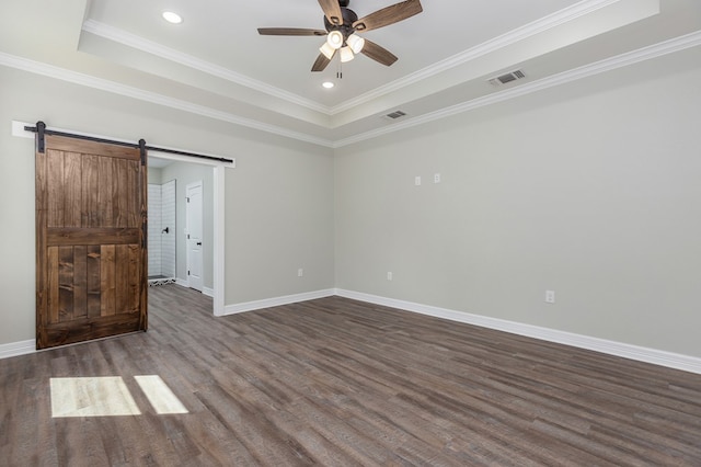 unfurnished bedroom featuring a barn door, a raised ceiling, and visible vents