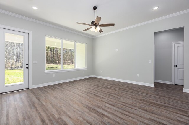 spare room with baseboards, dark wood-type flooring, and crown molding