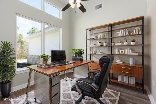 office space featuring dark wood-style floors, visible vents, ceiling fan, and baseboards