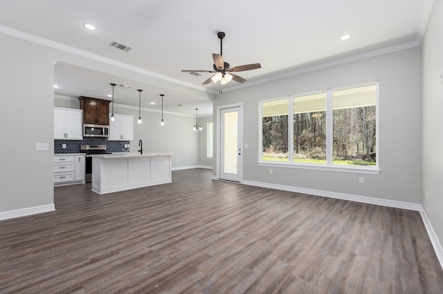 unfurnished living room with visible vents, crown molding, and baseboards