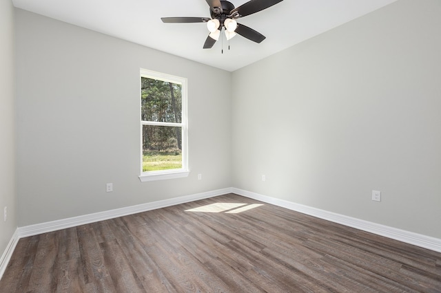 spare room with ceiling fan, dark wood-style flooring, and baseboards