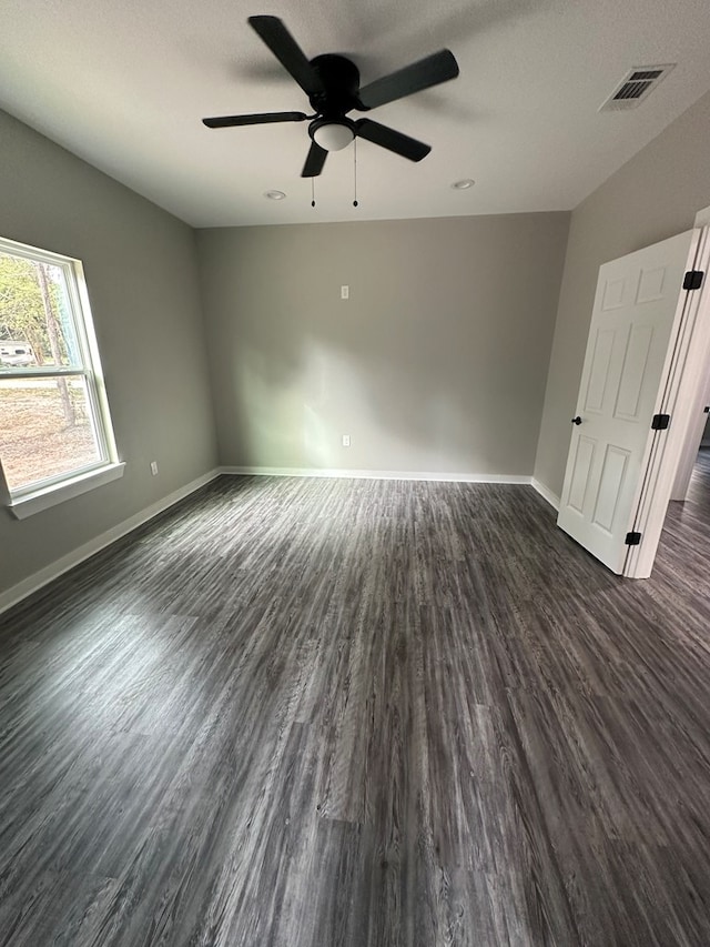 unfurnished room with ceiling fan, dark hardwood / wood-style flooring, and a textured ceiling