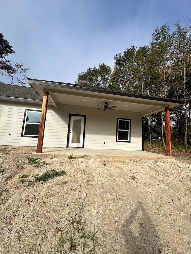 rear view of property featuring ceiling fan and a patio