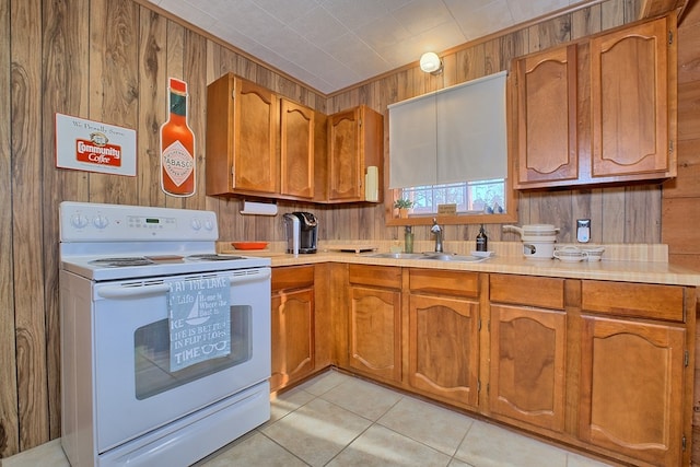 kitchen featuring a sink, brown cabinets, wooden walls, and white range with electric cooktop