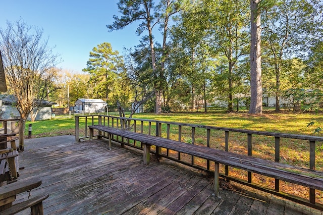 wooden terrace featuring a yard and a storage unit