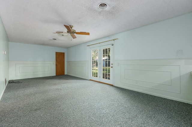 empty room featuring ceiling fan, carpet floors, and a textured ceiling