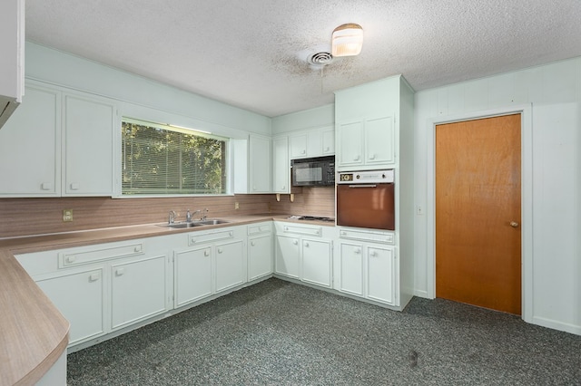 kitchen with white cabinetry, sink, wall oven, a textured ceiling, and stainless steel gas stovetop