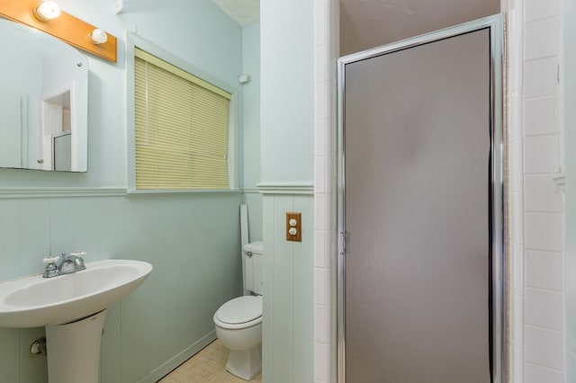 bathroom with tile patterned floors, sink, a shower with door, and toilet