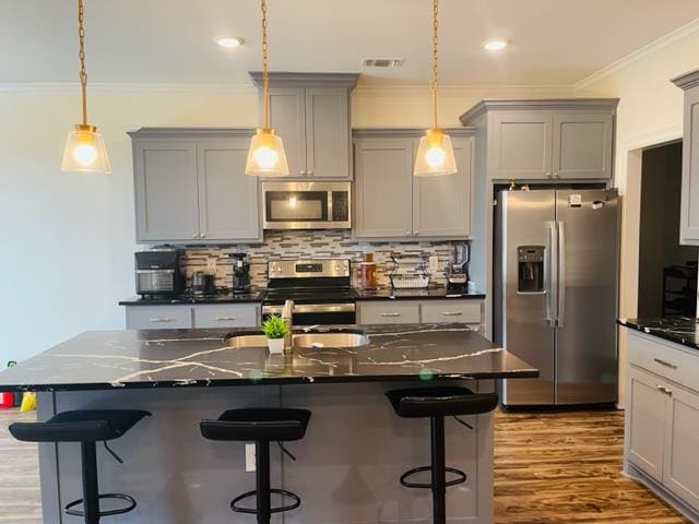 kitchen featuring a kitchen island, dark stone countertops, and appliances with stainless steel finishes