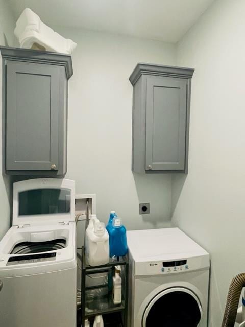 clothes washing area with cabinets and washer / clothes dryer