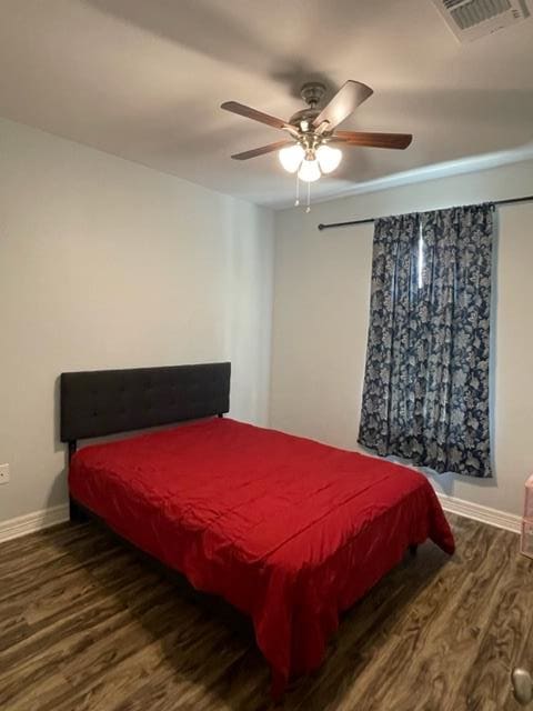 bedroom featuring ceiling fan and dark wood-type flooring