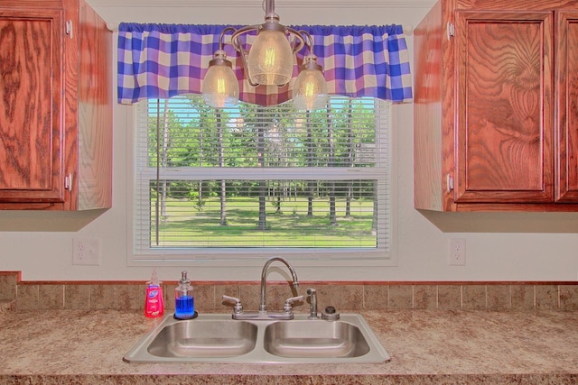 kitchen featuring sink, hanging light fixtures, and plenty of natural light