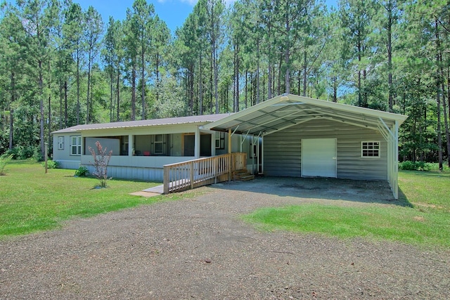 manufactured / mobile home with dirt driveway, a carport, a front lawn, and metal roof