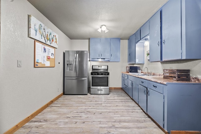 kitchen with blue cabinets, sink, light wood-type flooring, a textured ceiling, and stainless steel appliances