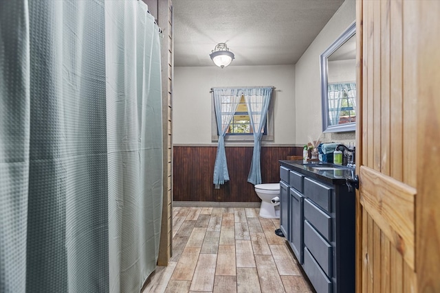 bathroom with hardwood / wood-style floors, vanity, plenty of natural light, and wooden walls