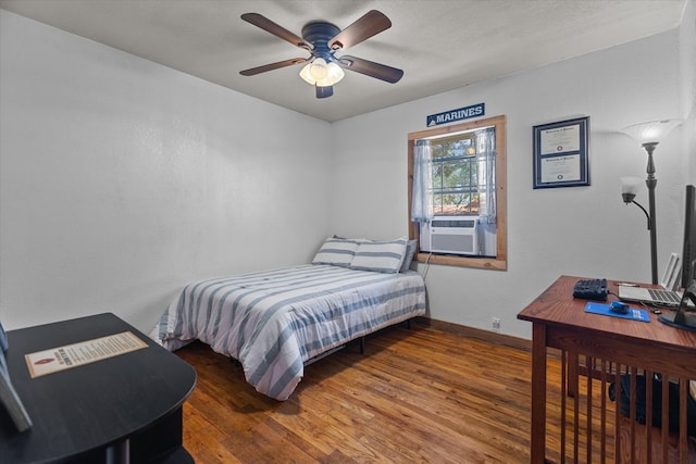 bedroom featuring ceiling fan, cooling unit, and dark wood-type flooring