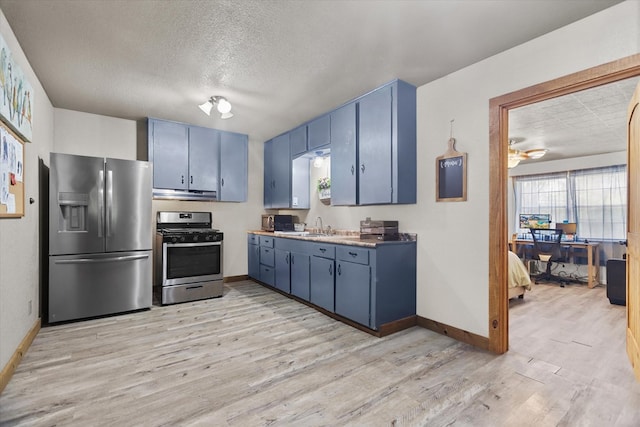 kitchen featuring blue cabinetry, appliances with stainless steel finishes, light hardwood / wood-style floors, and sink