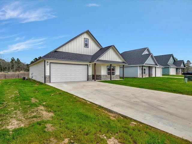 view of front of house with a garage, concrete driveway, stone siding, board and batten siding, and a front yard