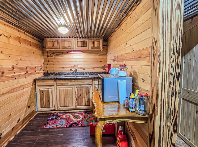 kitchen with wooden walls, a sink, wood ceiling, and wood-type flooring