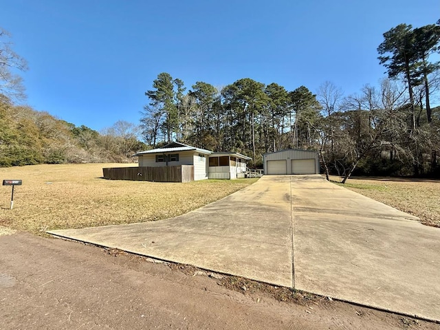 view of front of home with a garage, an outdoor structure, and a front lawn