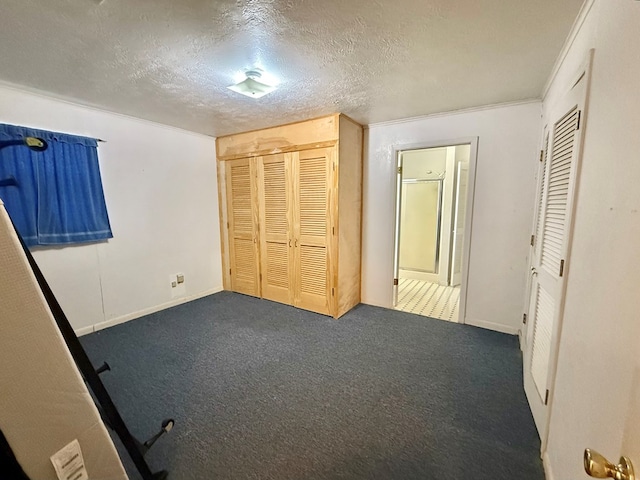 unfurnished bedroom with a closet, a textured ceiling, and dark colored carpet