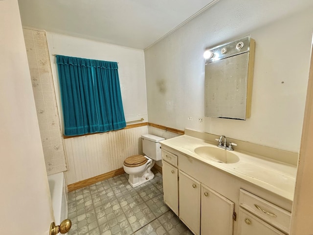 bathroom with vanity, a tub to relax in, and toilet