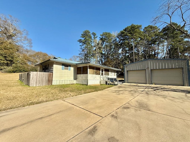 view of side of property featuring a garage, an outdoor structure, and a yard