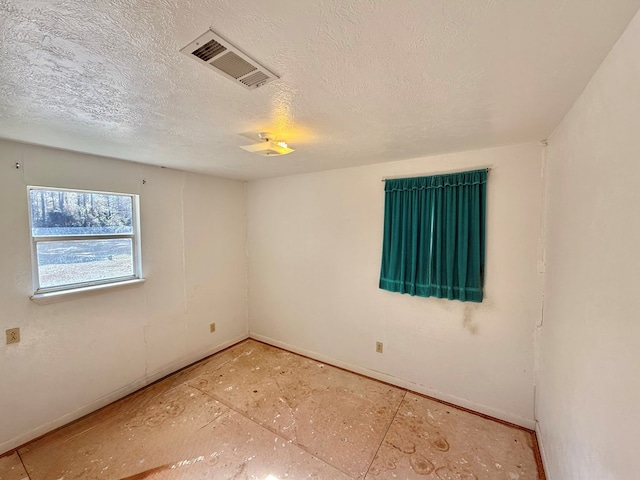 unfurnished room featuring a textured ceiling