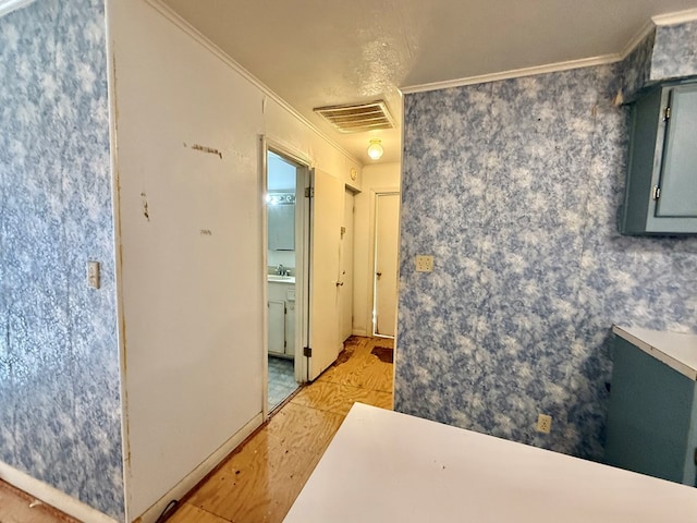 hallway featuring ornamental molding, sink, and light hardwood / wood-style flooring