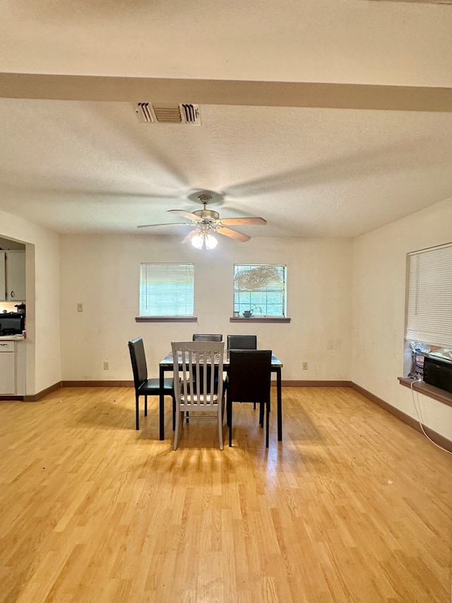 677 County Road 105, San Augustine, TX 75972 - dining space featuring baseboards, light wood-type flooring, a ceiling fan, and a textured ceiling