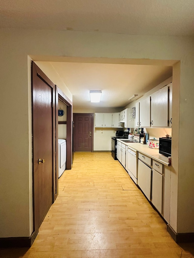 677 County Road 105, San Augustine, TX 75972 - kitchen with black range with electric cooktop, light wood-style flooring, white dishwasher, washer / clothes dryer, and light countertops