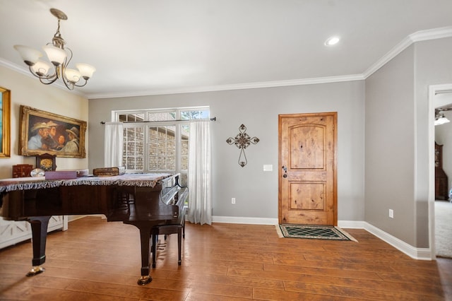entrance foyer featuring crown molding, hardwood / wood-style floors, baseboards, a notable chandelier, and recessed lighting