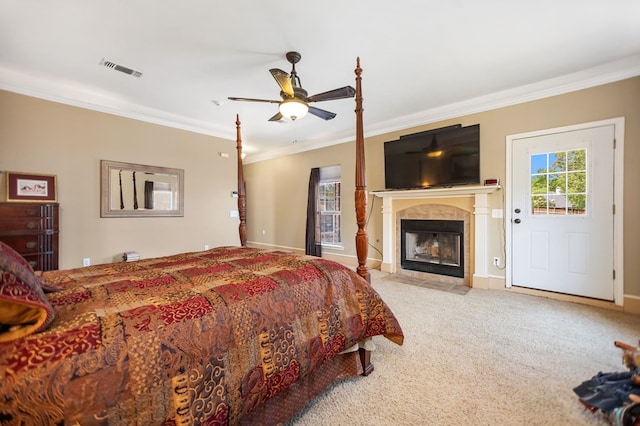 bedroom featuring baseboards, visible vents, a premium fireplace, crown molding, and carpet floors