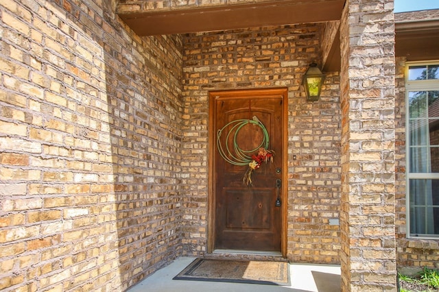 property entrance featuring brick siding