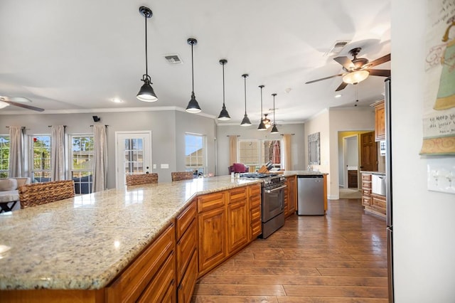 kitchen with brown cabinets, stainless steel appliances, visible vents, ornamental molding, and ceiling fan