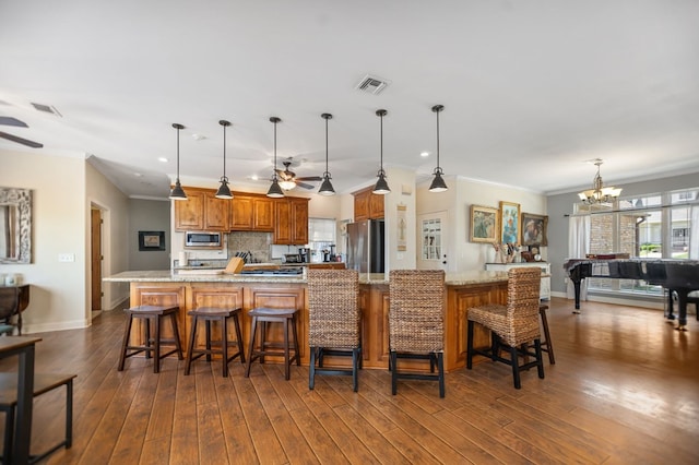 kitchen featuring dark wood finished floors, appliances with stainless steel finishes, visible vents, and ceiling fan with notable chandelier