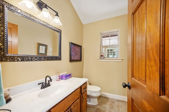 bathroom featuring vaulted ceiling, vanity, baseboards, toilet, and tile patterned flooring