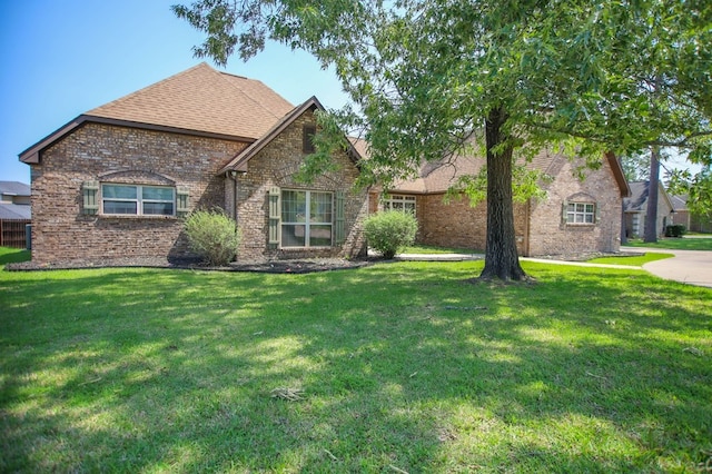 view of front of property featuring a front lawn and brick siding