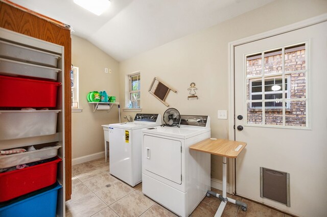 laundry room featuring baseboards, washing machine and clothes dryer, laundry area, and light tile patterned floors