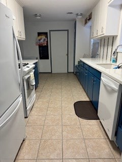 kitchen featuring dishwasher, blue cabinetry, refrigerator, stainless steel range oven, and white cabinetry