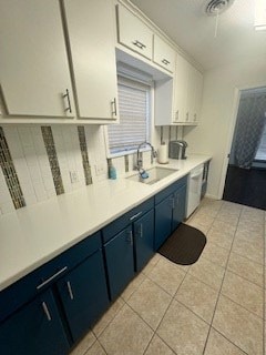 kitchen featuring sink, blue cabinets, and white cabinets