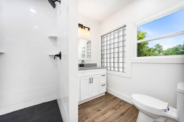 508 Jefferson Ave, Lufkin, TX 74904 - bathroom featuring vanity, tiled shower, toilet, wood finished floors, and baseboards