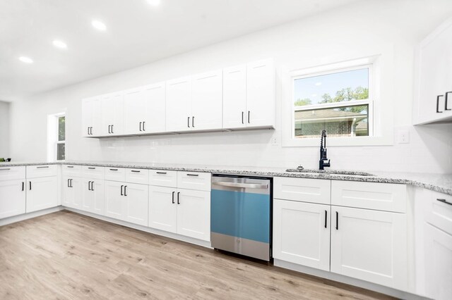 508 Jefferson Ave, Lufkin, TX 74904 - kitchen featuring stainless steel dishwasher, a sink, light wood finished floors, white cabinetry, and recessed lighting