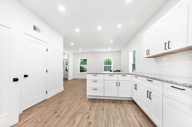 508 Jefferson Ave, Lufkin, TX 74904 - kitchen featuring a peninsula, light wood-type flooring, recessed lighting, white cabinets, and light stone counters