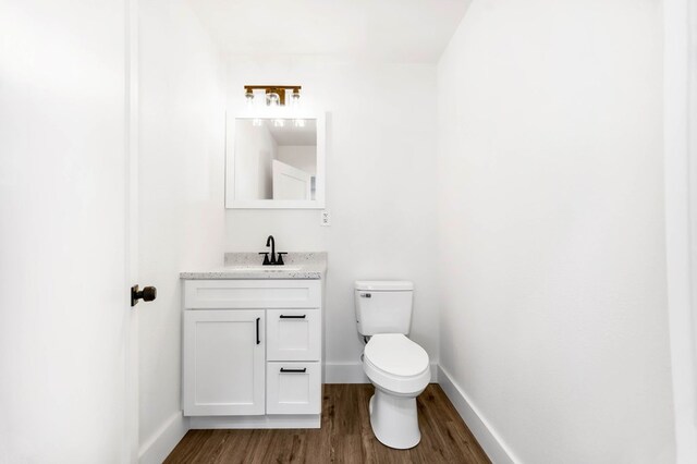508 Jefferson Ave, Lufkin, TX 74904 - bathroom featuring vanity, wood finished floors, toilet, and baseboards