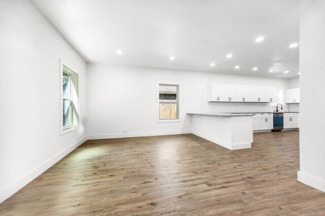 508 Jefferson Ave, Lufkin, TX 74904 - unfurnished living room with recessed lighting, baseboards, light wood finished floors, and a sink